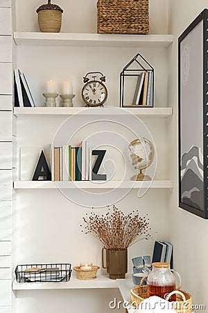 Bookends with books and decor on shelves indoors. Interior design Stock Photo