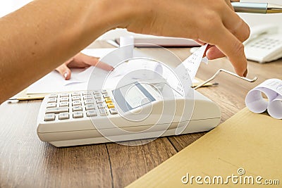 Bookkeeper doing calculations on an adding machine Stock Photo