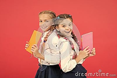 These books are absolutely genius. Genius little children smiling on red background. Happy genius girls or wonder kids Stock Photo