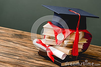 Books, academic cap, medal and diploma on on grey Stock Photo