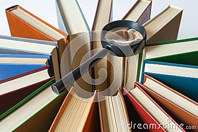 Books are arranged in a circle in the center on them lies a magnifying glass (search concept) Stock Photo