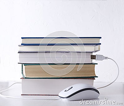 Books and computer mouse against white wall.Concept of e-learning Stock Photo