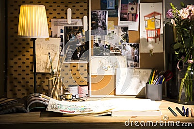 Books and drafts on wooden table under lamp light Stock Photo