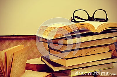 Books and eyeglasses in an old suitcase, with a retro effect Stock Photo