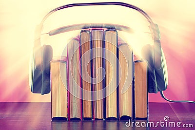 Books and headphones as an audiobook concept on a wooden table Stock Photo