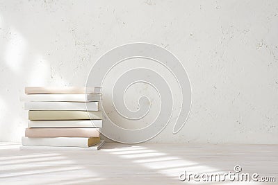 Books stack with light shadows from window on wooden table Stock Photo