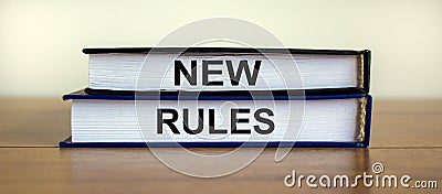 Books with text `new rules` on wooden table. Beautiful white background. Business concept, copy space Stock Photo