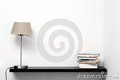 Bookshelf on the wall with lamp and books Stock Photo