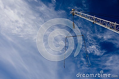 Boom crane with a cable against the blue sky. Background. Copy space Stock Photo