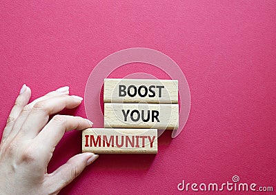 Boost your immunity symbol. Concept word Boost your immunity on wooden blocks. Doctor hand. Beautiful red background. Helthcare Stock Photo