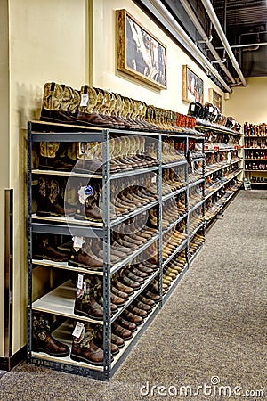 Rows of cowboy boots on shelves in a Boot Barn store. Editorial Stock Photo