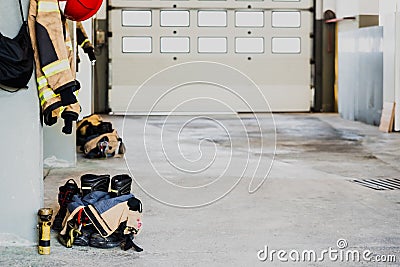 Boots and fireman`s jacket on the garage floor of a fire station Stock Photo