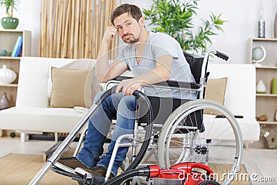 borde disabled man in wheelchair uses vacuum cleaner Stock Photo