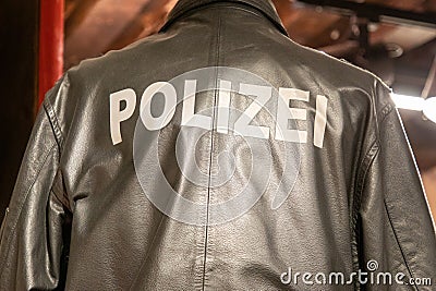 Polizei text sign on the back of german police man wearing leather jacket rear view Stock Photo