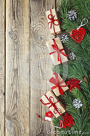 Border from the pine branches, Christmas decorations and gift boxes on an old wooden table. Holidays Christmas background. Space Stock Photo