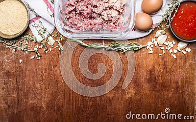 Border with Raw ground beef garlic herb breadcrumbs eggs tomato sauce on a white napkin rustic wooden background close up Stock Photo