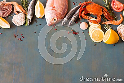 Bordure of fresh seafood, crab and fish on blue wooden background with copy space. Stock Photo