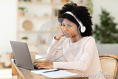 Bored African American Teen Girl Sitting At Laptop At Home Stock Photo