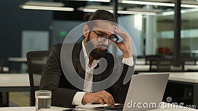 Bored Arabian business man at office table tired Indian clerk businessman worker sad dissatisfied disinterest manager Stock Photo