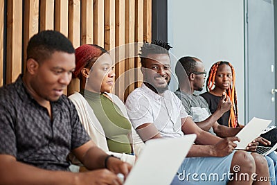 Bored business people sit on chairs waiting for an interview Stock Photo