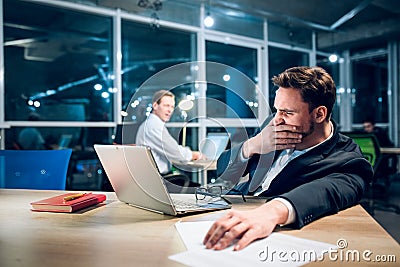 Young tired businessman working at night. Stock Photo