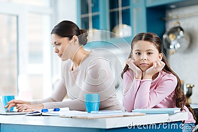 Bored child standing near her mom working Stock Photo