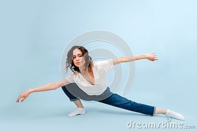 Bored contemporary dancer in a lunge with arms spread apart in a straight line Stock Photo