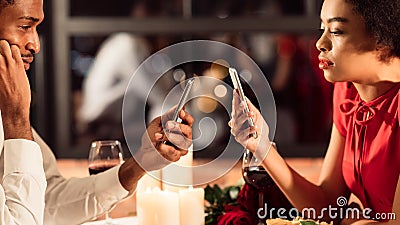 Bored Couple Using Smartphones On Romantic Dinner In Restaurant, Panorama Stock Photo