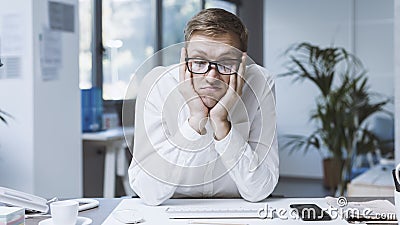 Bored employee sitting at desk and doing nothing Stock Photo