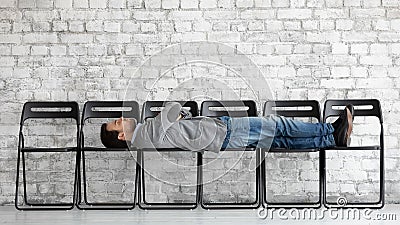 Bored exhausted candidate lying on office chairs, waiting for interview Stock Photo