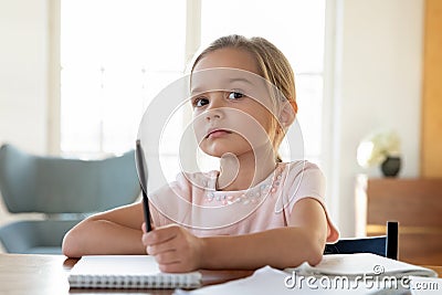 Bored little girl look in distance distracted from studying Stock Photo
