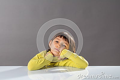 Bored little sleepy child daydreaming, meditating for confused education, studio Stock Photo