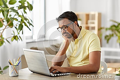 Bored man with laptop working at home office Stock Photo