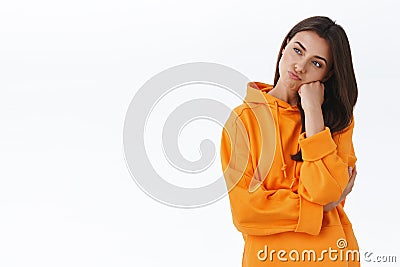 Bored pretty caucasian girl thinking what do on weekends, pouting and leaning on hand looking left thoughtful, trying Stock Photo