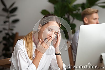 Bored tired businesswoman yawning at workplace feeling lack of s Stock Photo