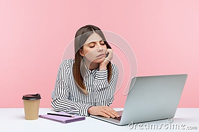 Bored unhappy business woman sitting at workplace looking at laptop display having video call, tired of online conference, Stock Photo