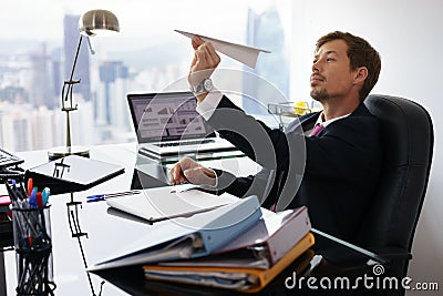 Bored White Collar Worker Throwing Paper Airplane In Office Stock Photo