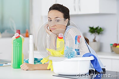 Bored woman looking at cleaning products Stock Photo