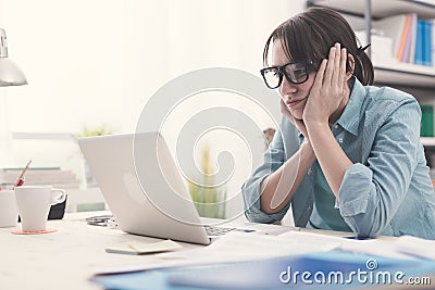 Bored woman working with her laptop Stock Photo