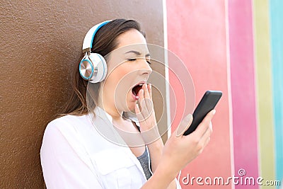 Bored woman yawning using smart phone Stock Photo