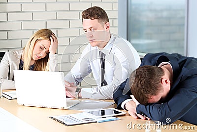 Boring work. Young business people looking bored while sitting together at the table and looking away Stock Photo