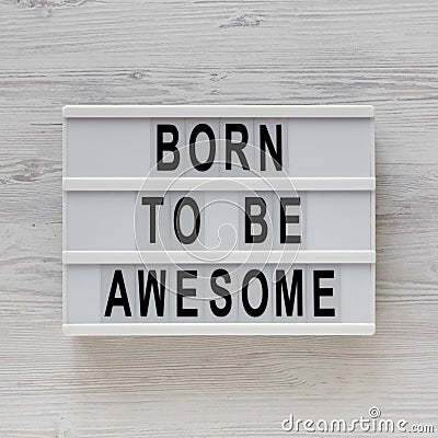 `Born to be awesome` words on a modern board on a white wooden background, top view. Overhead, from above, flat lay Stock Photo