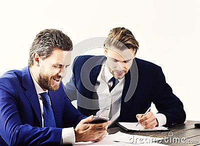 Boss gives instructions to employee. Busy people with smiling faces write papers. Boss in formal suit surfs internet Stock Photo