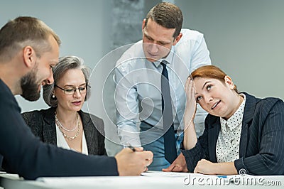 The boss gives instructions to three employees in the office conference room. Brainstorming engineers and architects. Stock Photo