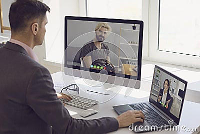 Boss making video calls to employees in home office. Stock Photo