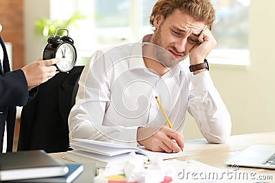 Boss reminding young man of duration in office Stock Photo