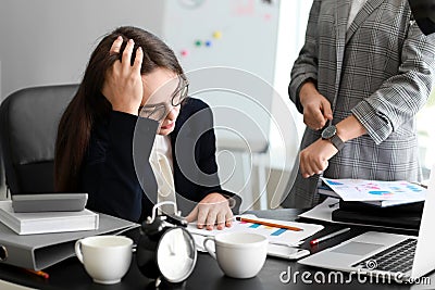 Boss reminding young woman of duration in office Stock Photo