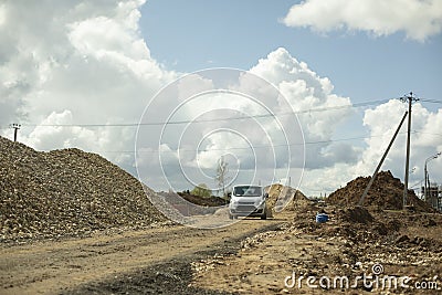 Boss`s car is at construction site. Construction of road. Mound of sand Stock Photo