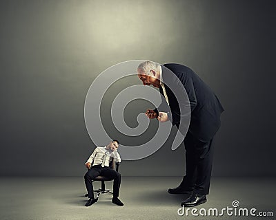 Boss screaming at small lazy worker Stock Photo