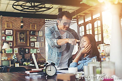 Boss shouting to a stressed employee when she work with laptop a Stock Photo